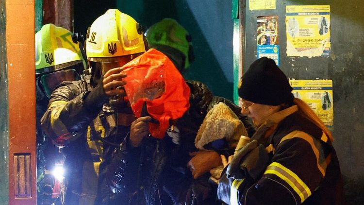 Bombeiros auxiliam um morador com máscara de resgate durante a evacuação de um prédio atingido por um ataque de drone russo durante a madrugada, em meio ao ataque da Rússia à Ucrânia, em Kiev, Ucrânia, 25 de novembro de 2025. REUTERS/Valentyn 