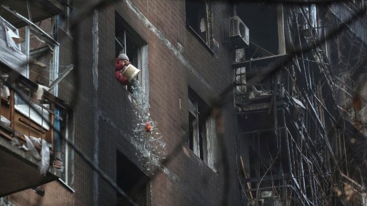 Uma moradora atira cacos de vidro das janelas de seu apartamento em um prédio danificado por um ataque de drone russo, ocorrido no final da noite de segunda-feira, em meio ao ataque da Rússia à Ucrânia, na cidade de Kramatorsk, região de Donetsk, Ucrânia, em 2 de dezembro de 2025. REUTERS/Anatolii Stepanov