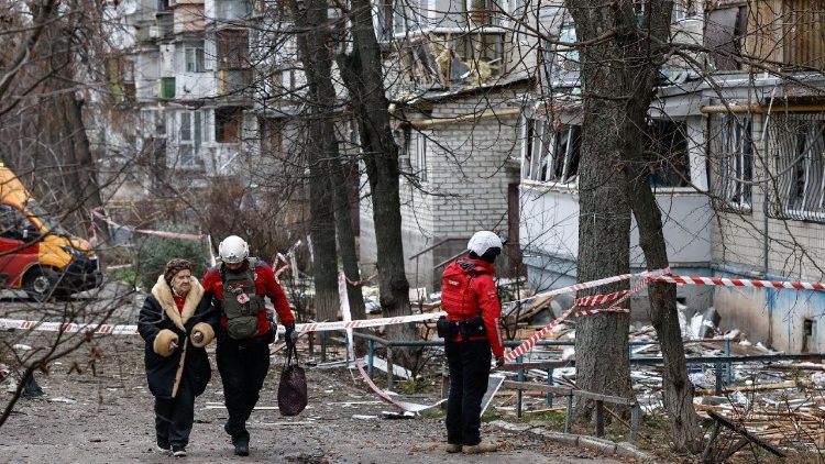 Um membro da equipe de emerg&ecirc;ncia auxilia uma idosa que estava dentro de um pr&eacute;dio de apartamentos danificado por um ataque de drone russo, em meio ao ataque da R&uacute;ssia &agrave; Ucr&acirc;nia, em Kiev, Ucr&acirc;nia, em 23 de dezembro de 2025. REUTERS/Thomas Peter