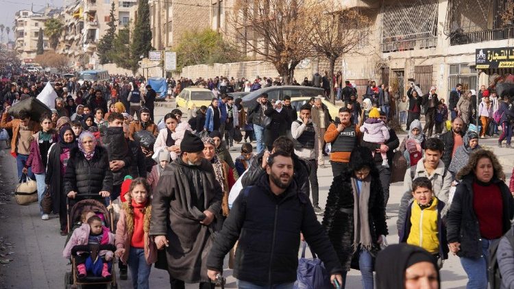 Los civiles llevan sus maletas y pertenencias mientras huyen tras los nuevos enfrentamientos entre el ejército sirio y las Fuerzas Democráticas Sirias.