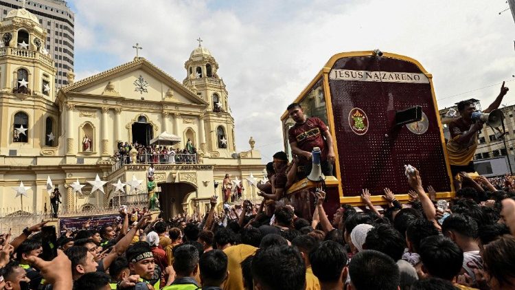 Filipino Catholic devotees surround the carriage carrying the statue of the Black Nazarene as it is returned to Quiapo Church during the annual procession
