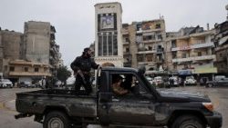 A member of the Syrian army stands on a pick-up truck in Aleppo