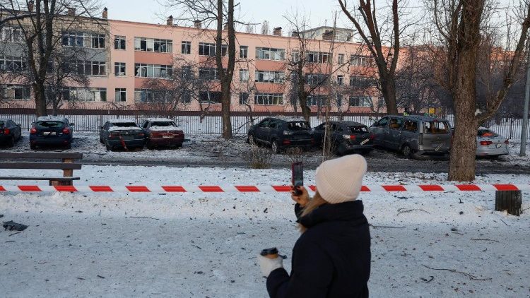 Um morador fotografa carros e um pr&eacute;dio escolar danificados durante um ataque de drone russo, em meio ao ataque da R&uacute;ssia &agrave; Ucr&acirc;nia, em Kiev, Ucr&acirc;nia, 20 de janeiro de 2026. REUTERS/Valentyn Ogirenko
