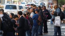 People wait at a bus stop in Venezuelan capital Caracas