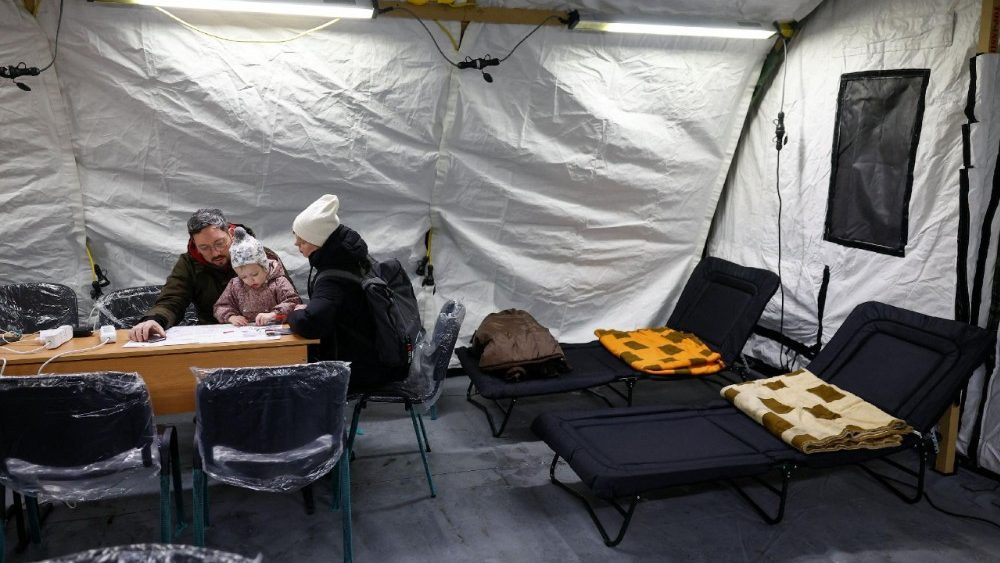 Moradores se aquecem dentro de uma tenda de um ponto de ajuda humanitária administrado pelo governo, onde as pessoas podem carregar seus dispositivos, obter refeições quentes, bebidas e apoio psicológico. A tenda foi instalada ao lado de prédios residenciais durante um apagão após infraestruturas civis críticas terem sido atingidas por recentes ataques de mísseis e drones russos, em meio ao ataque da Rússia à Ucrânia, em Kiev, Ucrânia, 25 de janeiro de 2026. REUTERS/Valentyn Ogirenko