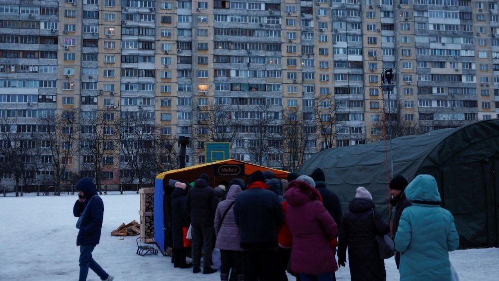 Moradores recebem refeições quentes de voluntários ao lado de tendas em um ponto de ajuda humanitária administrado pelo governo, onde as pessoas podem se aquecer, carregar seus dispositivos, tomar bebidas e refeições quentes e receber apoio psicológico, durante um apagão após infraestruturas civis críticas terem sido atingidas por recentes ataques de mísseis e drones russos, em meio ao ataque da Rússia à Ucrânia, em Kiev, Ucrânia, 30 de janeiro de 2026. REUTERS/Valentyn Ogirenko