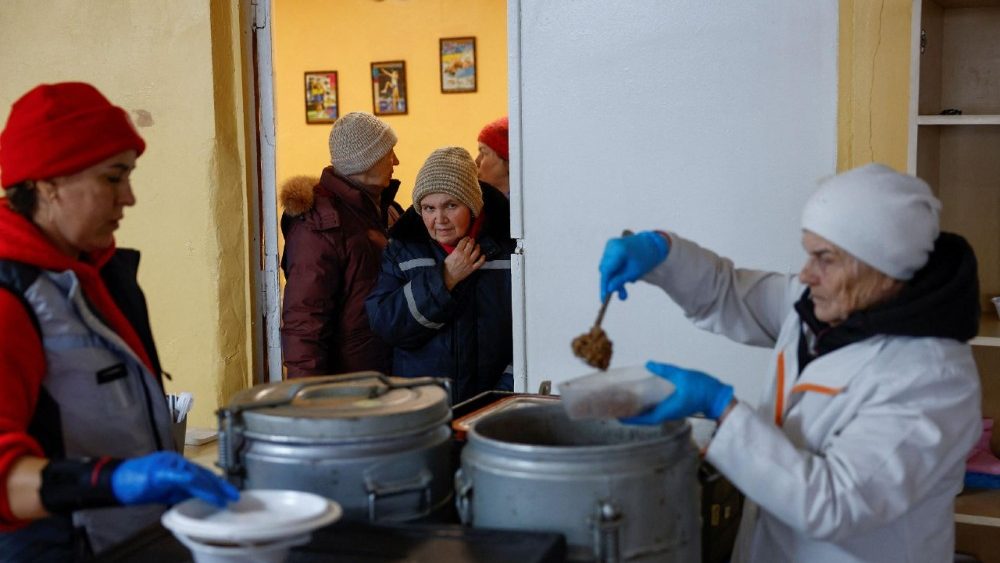 Moradores aguardam refeições quentes preparadas por voluntários dentro de um prédio escolar que foi transformado em um ponto de ajuda humanitária, onde as pessoas podem se aquecer, dormir, carregar seus dispositivos, tomar bebidas quentes e receber apoio psicológico, durante um apagão após infraestruturas civis críticas terem sido atingidas por recentes ataques de mísseis e drones russos, em meio ao ataque da Rússia à Ucrânia, em Kiev, Ucrânia, 30 de janeiro de 2026. REUTERS/Valentyn Ogirenko
