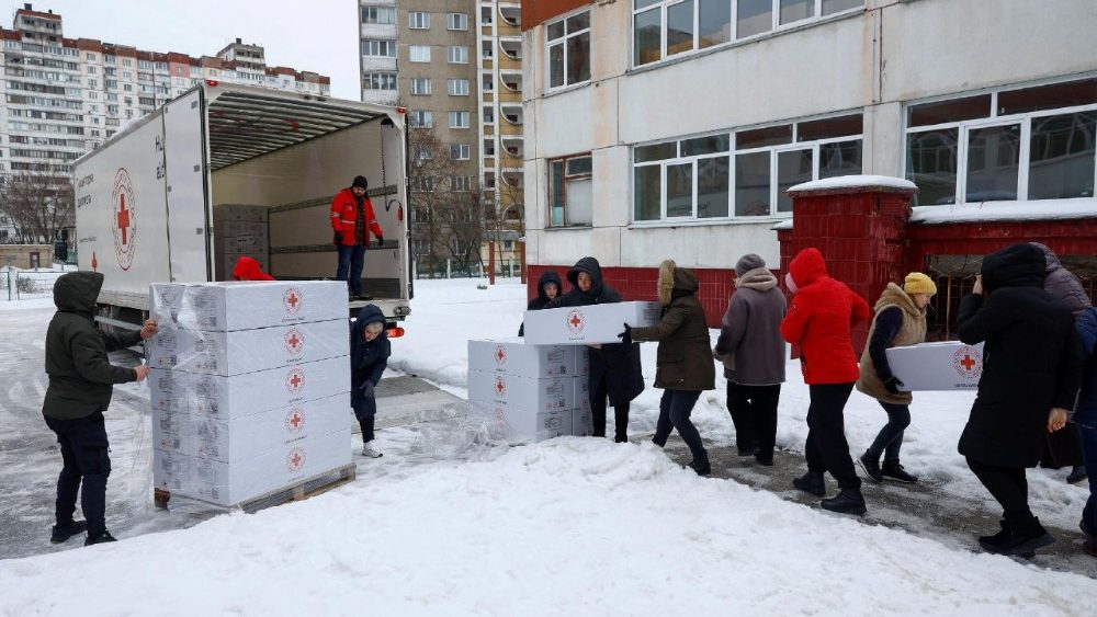 Professores e funcionários levam kits de dormir entregues pela Cruz Vermelha para dentro de um prédio escolar que foi transformado em um ponto de ajuda humanitária, onde as pessoas podem se aquecer, carregar seus dispositivos, tomar bebidas quentes e receber apoio psicológico, durante um apagão após infraestruturas civis críticas terem sido atingidas por recentes ataques de mísseis e drones russos, em meio ao ataque da Rússia à Ucrânia, em Kiev, Ucrânia, 30 de janeiro de 2026. REUTERS/Valentyn Ogirenko