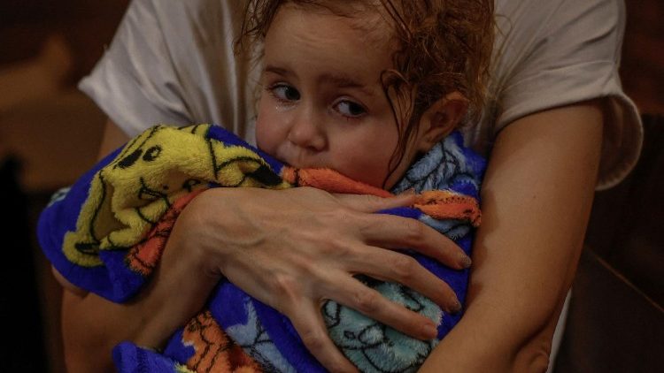 Yuliia Davydenko, de 40 anos, segura sua filha Stephanie, de 2 anos, enrolada em uma toalha ap&oacute;s tomar banho em um banheiro p&uacute;blico, j&aacute; que seu apartamento n&atilde;o tem aquecimento nem &aacute;gua quente e enfrenta frequentes cortes de energia em meio aos ataques da R&uacute;ssia &agrave; Ucr&acirc;nia, em Kiev, Ucr&acirc;nia, 3 de fevereiro de 2026. Ondas de ataques russos nos &uacute;ltimos quatro meses deixaram centenas de milhares de pessoas sem eletricidade e &aacute;gua, tornando este o inverno mais devastador desde o in&iacute;cio da guerra; e assim, a fam&iacute;lia Davydenko optou por ficar no Piggy Cafe Kyiv, de propriedade da fam&iacute;lia, com energia fornecida por um gerador e aquecimento. "O momento em que decidiremos deixar Kiev novamente ser&aacute; quando as tropas russas estiverem a 10-12 km da cidade. S&oacute; isso", disse Yuliia Davydenko, de 40 anos. REUTERS/Alina Smutko