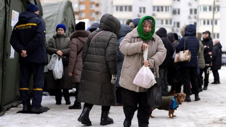Uma mulher carrega uma refei&ccedil;&atilde;o quente gratuita que recebeu em uma tenda aquecida dos servi&ccedil;os de emerg&ecirc;ncia em um bairro onde muitos apartamentos ficaram sem eletricidade e aquecimento ap&oacute;s os recentes ataques russos &agrave; infraestrutura civil da Ucr&acirc;nia, em Kiev, Ucr&acirc;nia, em 12 de fevereiro de 2026. REUTERS/Thomas Peter