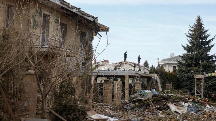 Homens removem destro&ccedil;os do telhado de uma casa em uma &aacute;rea residencial danificada por um ataque de m&iacute;ssil russo, em meio ao ataque da R&uacute;ssia &agrave; Ucr&acirc;nia, na regi&atilde;o de Kiev, Ucr&acirc;nia, em 22 de fevereiro de 2026. REUTERS/Valentyn Ogirenko