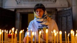 தாக்குதலில் உயிரிழந்தவர்களுக்கு அஞ்சலி செலுத்தும் உக்ரேனியப் பெண் 