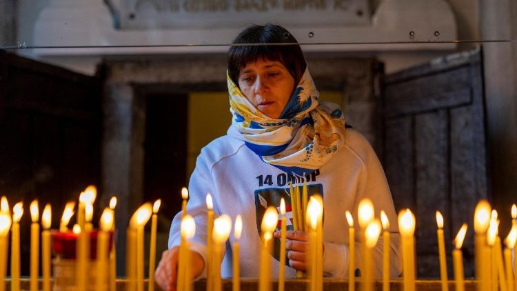 தாக்குதலில் உயிரிழந்தவர்களுக்கு அஞ்சலி செலுத்தும் உக்ரேனியப் பெண் 