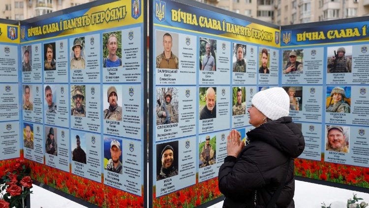 People visit a memorial dedicated to fallen Ukrainian defenders, in Kyiv