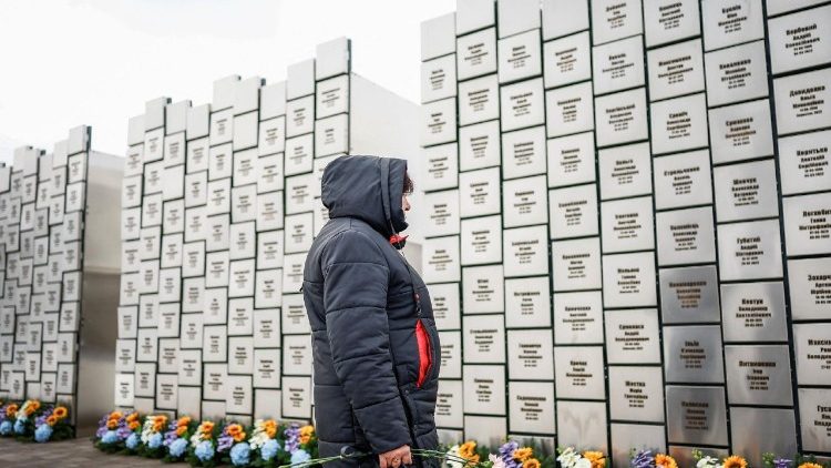 Uma mulher leva flores para prestar homenagem no memorial &agrave;s v&iacute;timas dos ataques e execu&ccedil;&otilde;es perpetrados por tropas russas, que marca o quarto anivers&aacute;rio da invas&atilde;o russa em grande escala, em meio ao ataque da R&uacute;ssia &agrave; Ucr&acirc;nia, na cidade de Bucha, regi&atilde;o de Kiev, Ucr&acirc;nia, em 24 de fevereiro de 2026. REUTERS/Alina Smutko