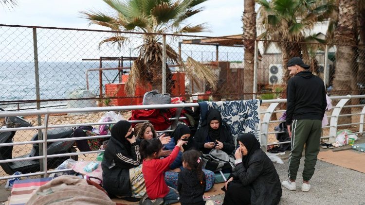 A family originally from Syria, displaced from the southern suburbs of Beirut, sits along a seaside corniche, following renewed hostilities between Hezbollah and Israel amid the U.S.-Israeli conflict with Iran, in Beirut, Lebanon