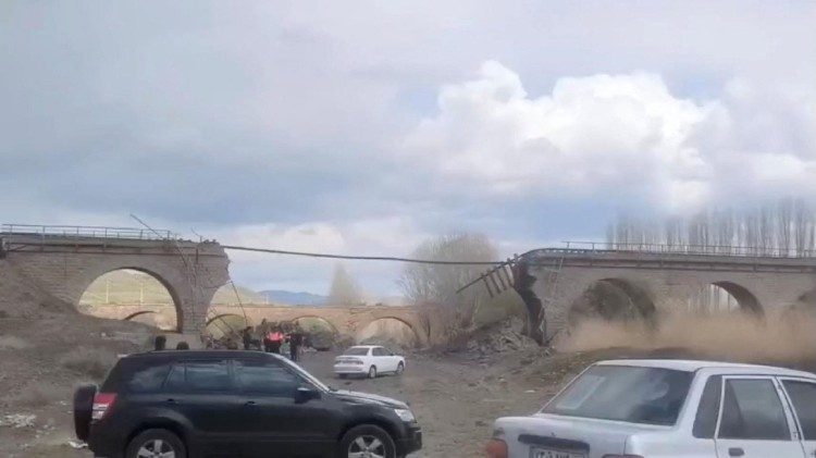 ज़ानजान प्रांत के अमीन अबाद में एक टूटे हुए पुल के पास लोग इकट्ठा हुए