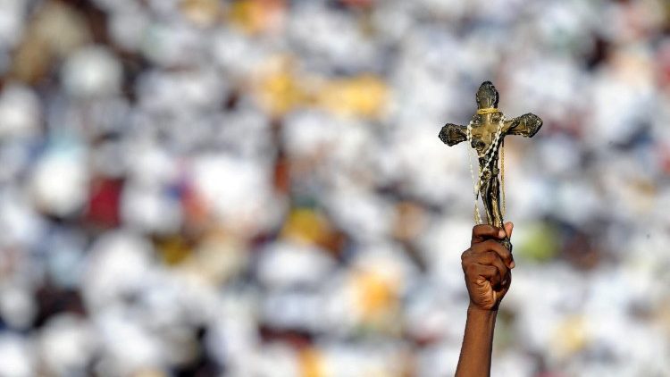 FILE PHOTO: लुआंडा के डॉस कोकेरोस स्टेडियम में एक युवा रैली के दौरान पोप बेनेडिक्ट 16वें को क्रूस दिखाते हुए श्रद्धालु