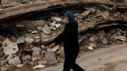 Una donna libanese cammina tra le macerie di un edificio colpito da un attacco israeliano a Zrarieh, Libano