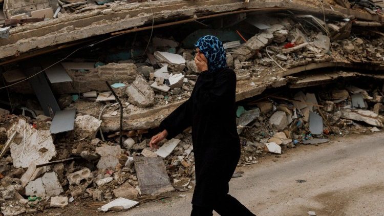 Una donna libanese cammina tra le macerie di un edificio colpito da un attacco israeliano a Zrarieh, Libano