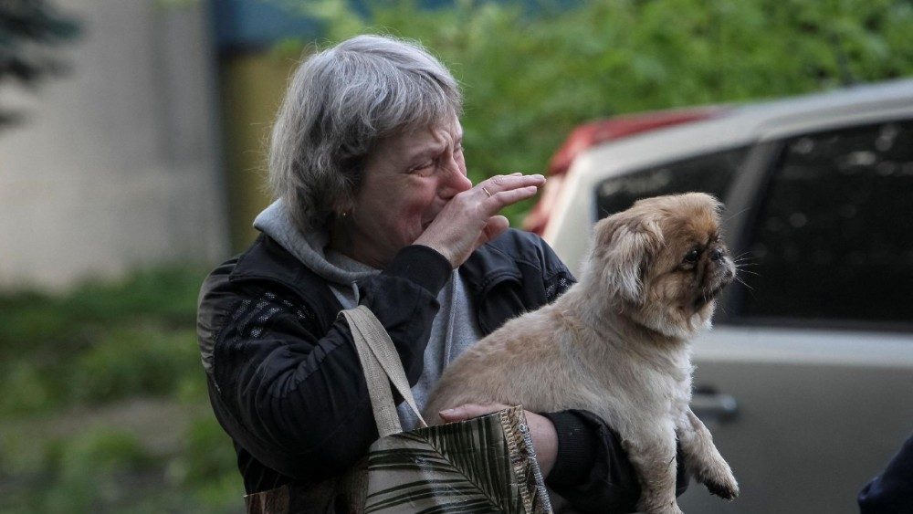 Uma mulher chora enquanto segura um cachorro no local de um prédio de apartamentos danificado durante um ataque de míssil russo, em meio ao ataque da Rússia à Ucrânia, em Dnipro, Ucrânia, em 18 de maio de 2026. REUTERS/Stringer