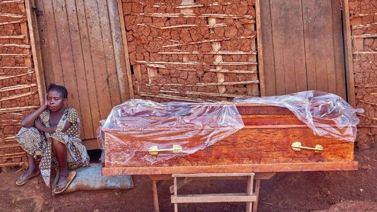 Uma mulher congolesa ao lado do caixão de um homem suspeito de ter morrido de Ebola
