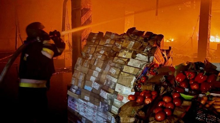Un vigile del fuoco spegne le fiamme presso un magazzino ATB-Market, una delle pi&ugrave; grandi catene di supermercati in Ucraina, colpito dall'attacco missilistico russo a Dnipro