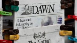 A newspaper displays coverage of the U.S.-Iran peace deal signing, at a newsstand in Islamabad