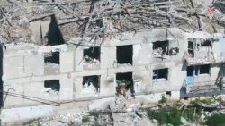 Un soldat brandissant un drapeau sur le site de bâtiments endommagés à Kostiantynivka, région de Donetsk en Ukraine. 
