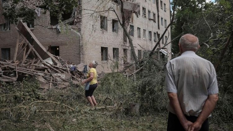 Moradores inspecionam um pr&eacute;dio de apartamentos danificado por um ataque militar russo, em meio &agrave; ofensiva da R&uacute;ssia contra a Ucr&acirc;nia, na cidade fronteiri&ccedil;a de Sloviansk, regi&atilde;o de Donetsk, Ucr&acirc;nia, em 21 de junho de 2026. REUTERS/Anatolii Stepanov