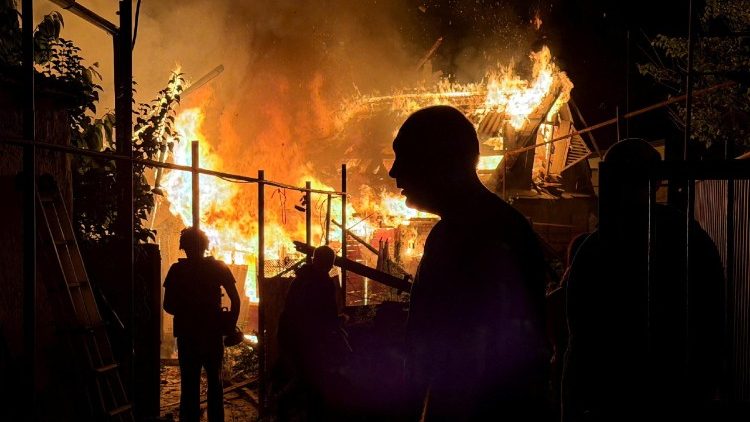 Moradores observam uma casa particular em chamas ap&oacute;s um ataque de drone russo durante a madrugada, em meio &agrave; ofensiva da R&uacute;ssia contra a Ucr&acirc;nia, em Zaporizhzhia, Ucr&acirc;nia, em 22 de junho de 2026. Foto tirada com um celular. REUTERS/Serhii Chalyi