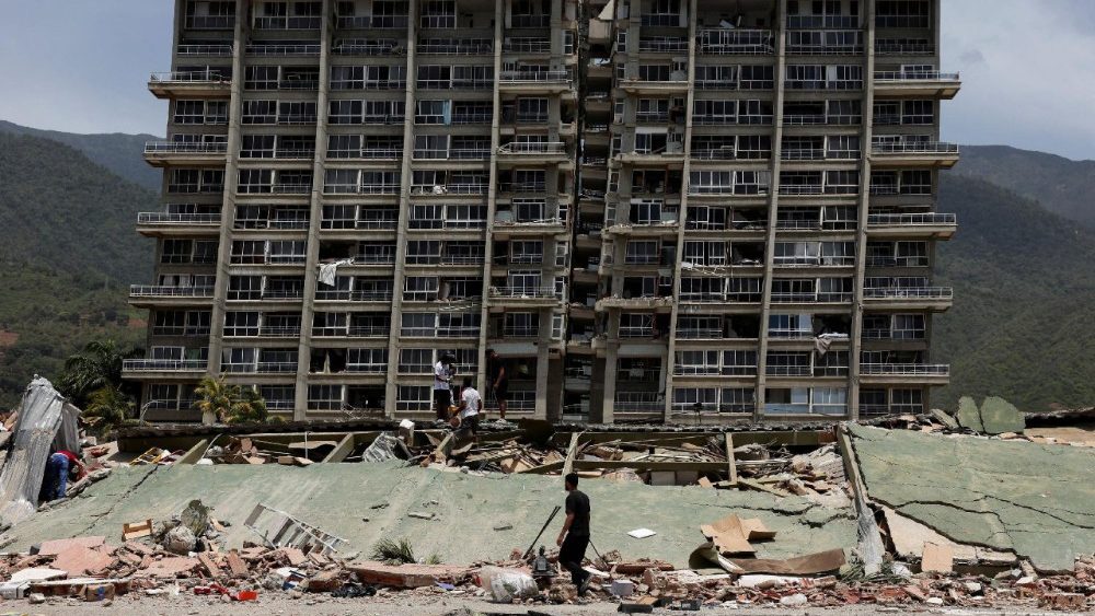Pessoas inspecionam os escombros de um prédio que desabou após terremotos atingirem o país, em La Guaira, Venezuela, em 25 de junho de 2026. REUTERS/Gaby Oraa