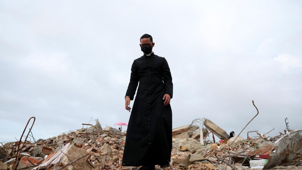 Um padre chamado Jean Carlos Cubera caminha sobre os escombros de um prédio que desabou após os terremotos em La Guaira, Venezuela, em 30 de junho de 2026. REUTERS/Ricardo Arduengo