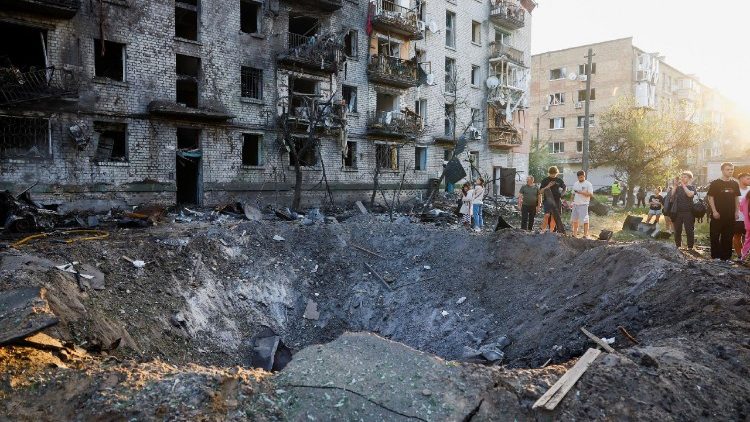 Moradores observam uma cratera formada em um local durante ataques noturnos com m&iacute;sseis e drones russos, em meio ao ataque da R&uacute;ssia &agrave; Ucr&acirc;nia, em Kiev, Ucr&acirc;nia, 2 de julho de 2026. REUTERS/Valentyn Ogirenko