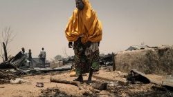 Una donna accanto ai suoi effetti personali dopo un incendio scoppiato mentre il WFP si preparava per la distribuzione di cibo nel campo profughi di Damasak, a Mobbar, nello Stato di Borno