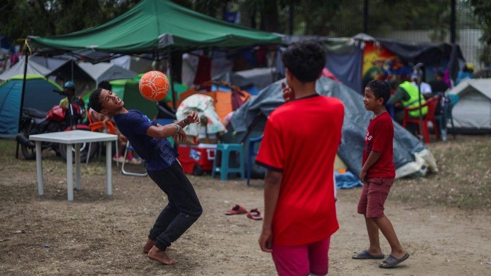 Crianças brincam com uma bola em um acampamento temporário para deslocados internos, após os terremotos de 24 de junho, em La Guaira, Venezuela, em 5 de julho de 2026. REUTERS/Adriano Machado