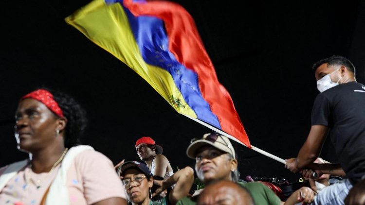 Un hombre flamea la bandera de Venezuela.