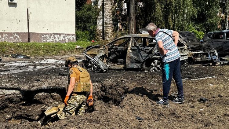 Um policial trabalha enquanto um morador observa o local de um ataque a&eacute;reo russo, em meio ao ataque da R&uacute;ssia &agrave; Ucr&acirc;nia, em Sumy, Ucr&acirc;nia, 15 de julho. Foto tirada com um celular. REUTERS/Stringer