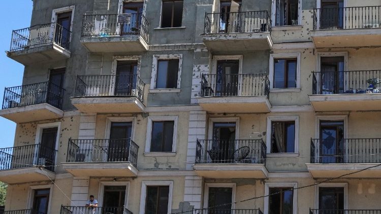 A resident stands on a balcony of an apartment building damaged by a Russian missile strike, amid Russia's attack on Ukraine, in Odesa, Ukraine July 15, 2026. REUTERS/Nina Liashonok