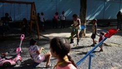 Children displaced by the earthquakes play in a makeshift shelter inside a school