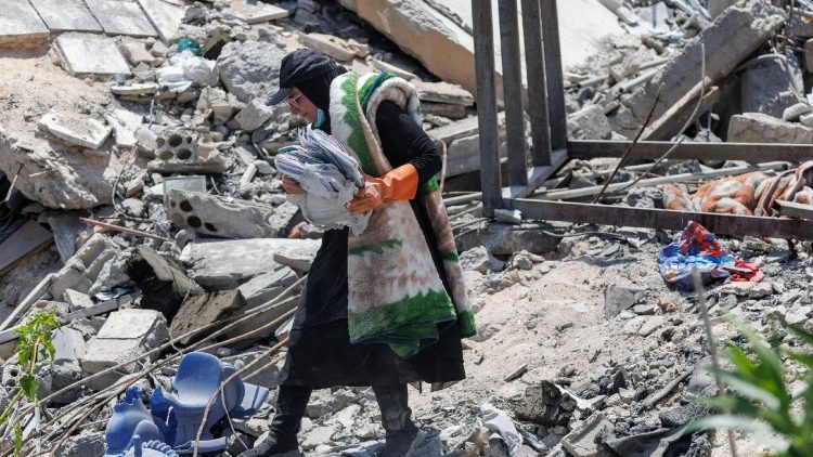 A Lebanese mother sifts through rubble of destroyed home in Zawtar al-Gharbiyeh