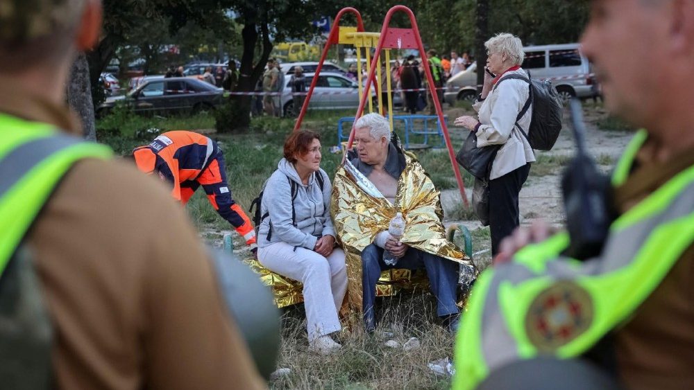 Moradores sentam-se no local de um prédio de apartamentos atingido por um ataque de míssil russo, em meio ao ataque da Rússia à Ucrânia, em Lviv, Ucrânia, em 30 de julho de 2026. REUTERS/Roman Baluk