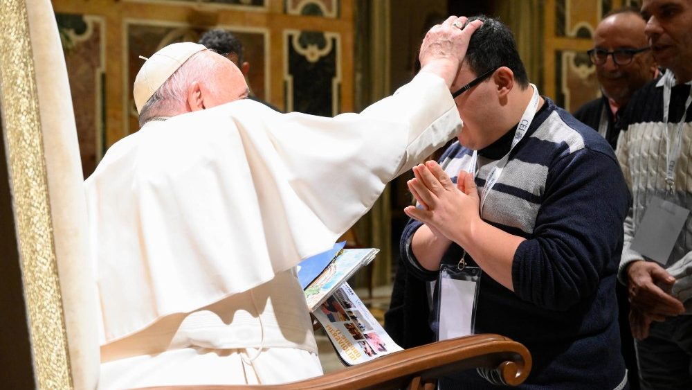 Der Papst segnet einen Menschen mit Behinderung