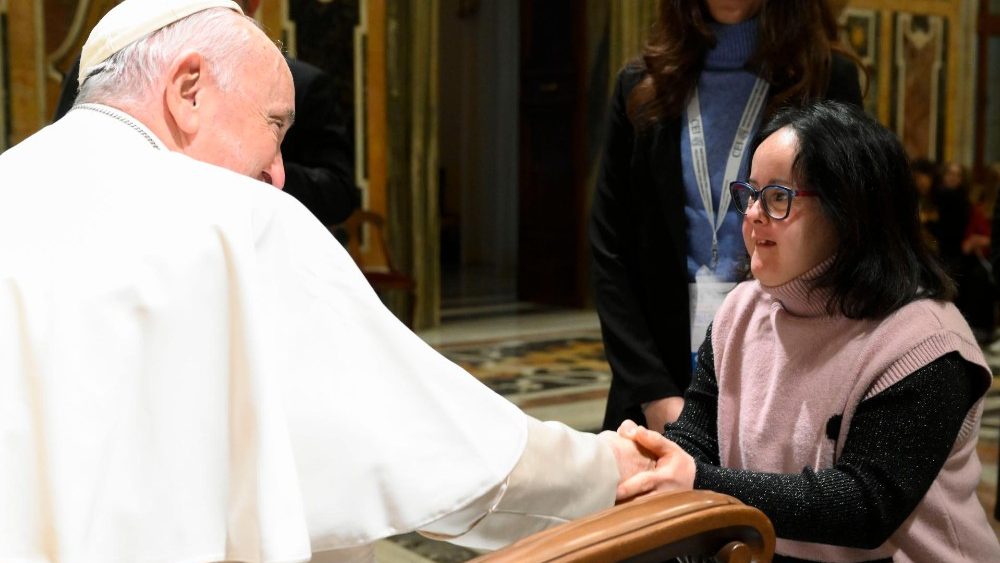 Papst Franziskus begrüßt eine Teilnehmerin persönlich