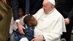 Papa Francisco abraça um menino na audiência aos refugiados que chegaram à Europa através dos corredores humanitários
