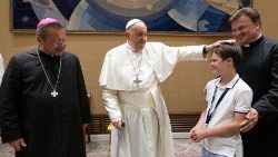 Pope Francis with a young pilgrim and Cardinal-elect Grzegorz Ryś (L)