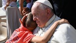 Ein Kind umarmt Papst Franziskus bei der Generalaudienz an diesem Mittwoch