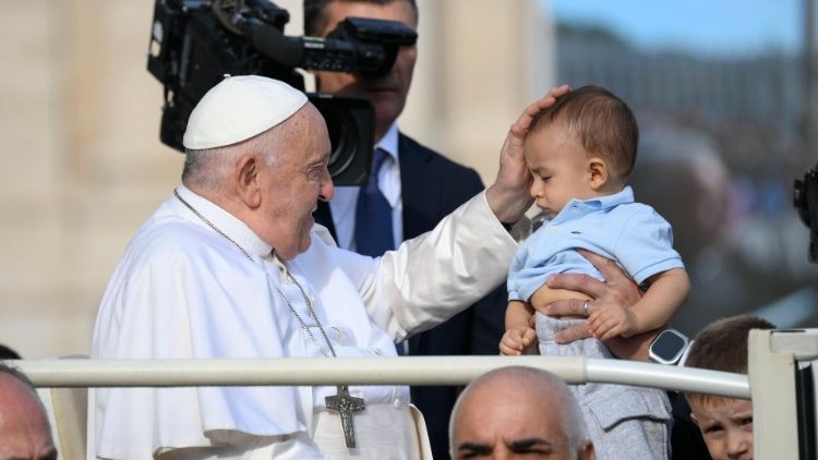 Papa Francesco benedice un bambino in Piazza San Pietro