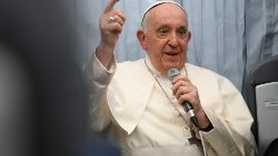 Pope Francis holds a microphone on the flight back from Marseille