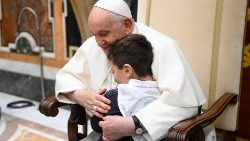 Pope Francis embraces a boy at the event on Monday